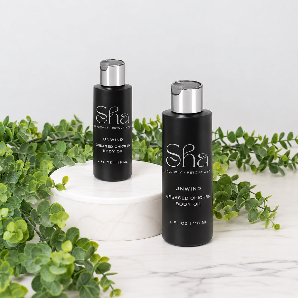 SHA Greased Chicken body oil in black bottles with silver caps